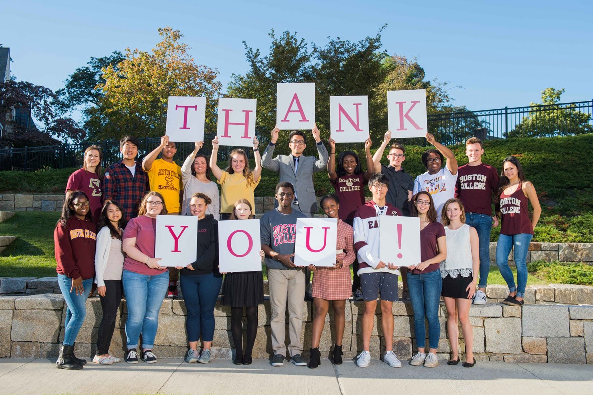 Boston College Students Holding small signs with single letters on them that spell out the phrase "thank you!"