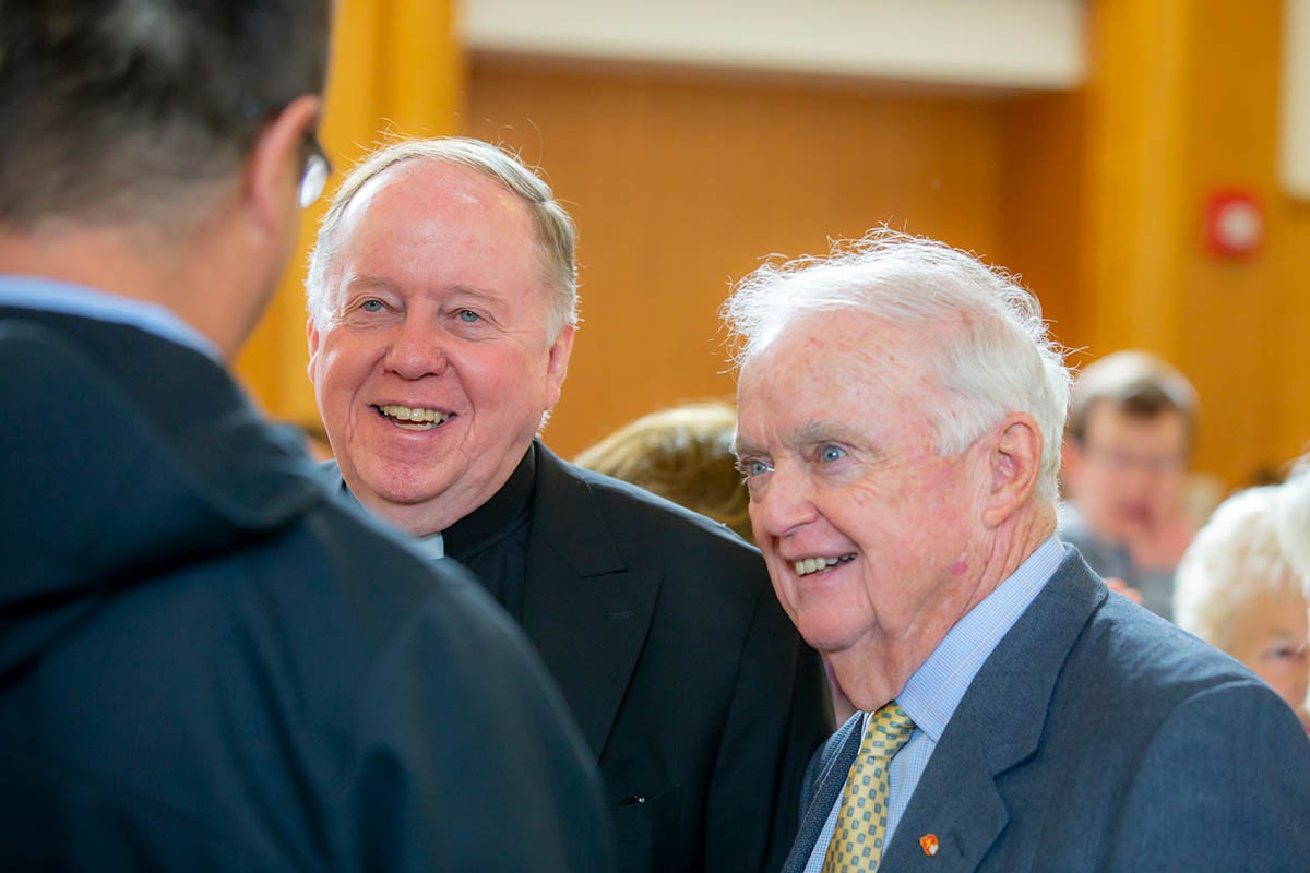 three men speaking with each other 