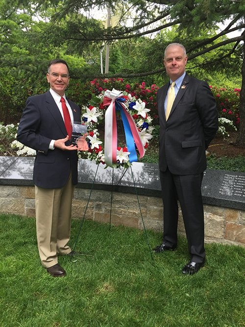 two men standing by a wreath