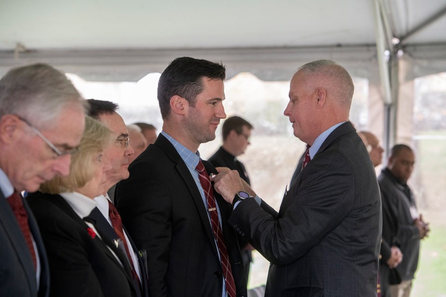 Colonel (ret.) Daniel M. Arkins, Jr. ’81, BCVAN Co-Chair, awards a BC Veteran pin to William Kelley CGSOM’18