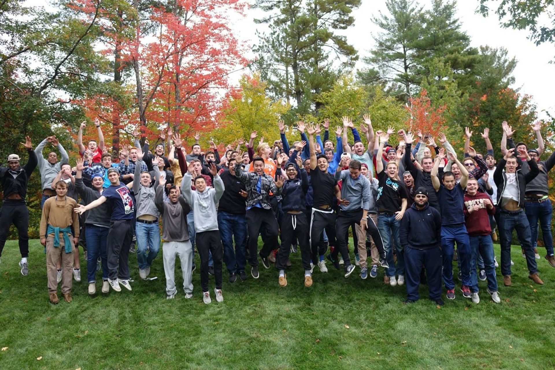 large group of the freshman, juniors and seniors jumping in the air