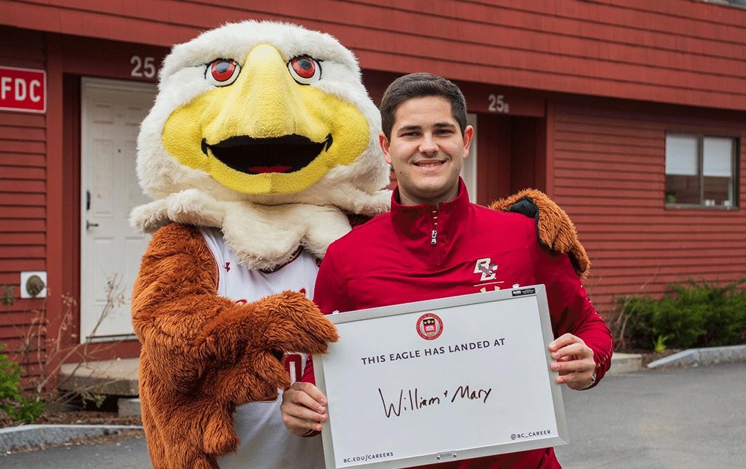 student holding a white board that says william and mary