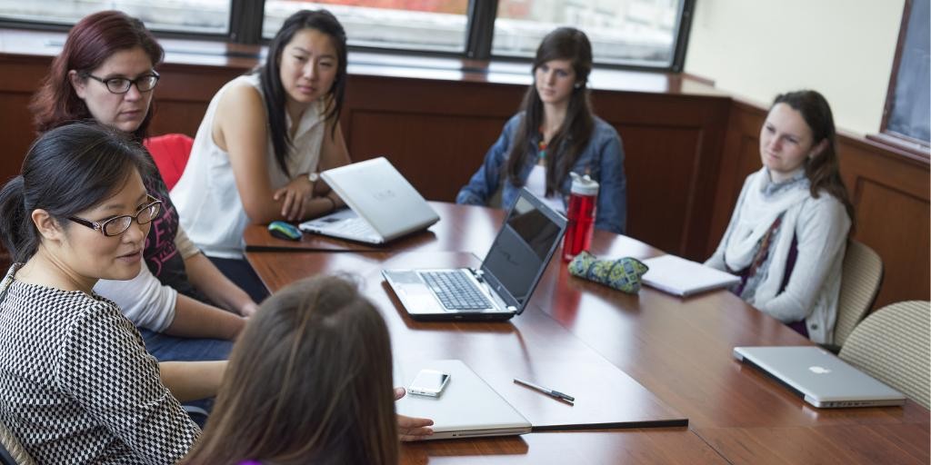 students and faculty sitting around a table 