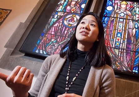 Faculty member in front of stained glass