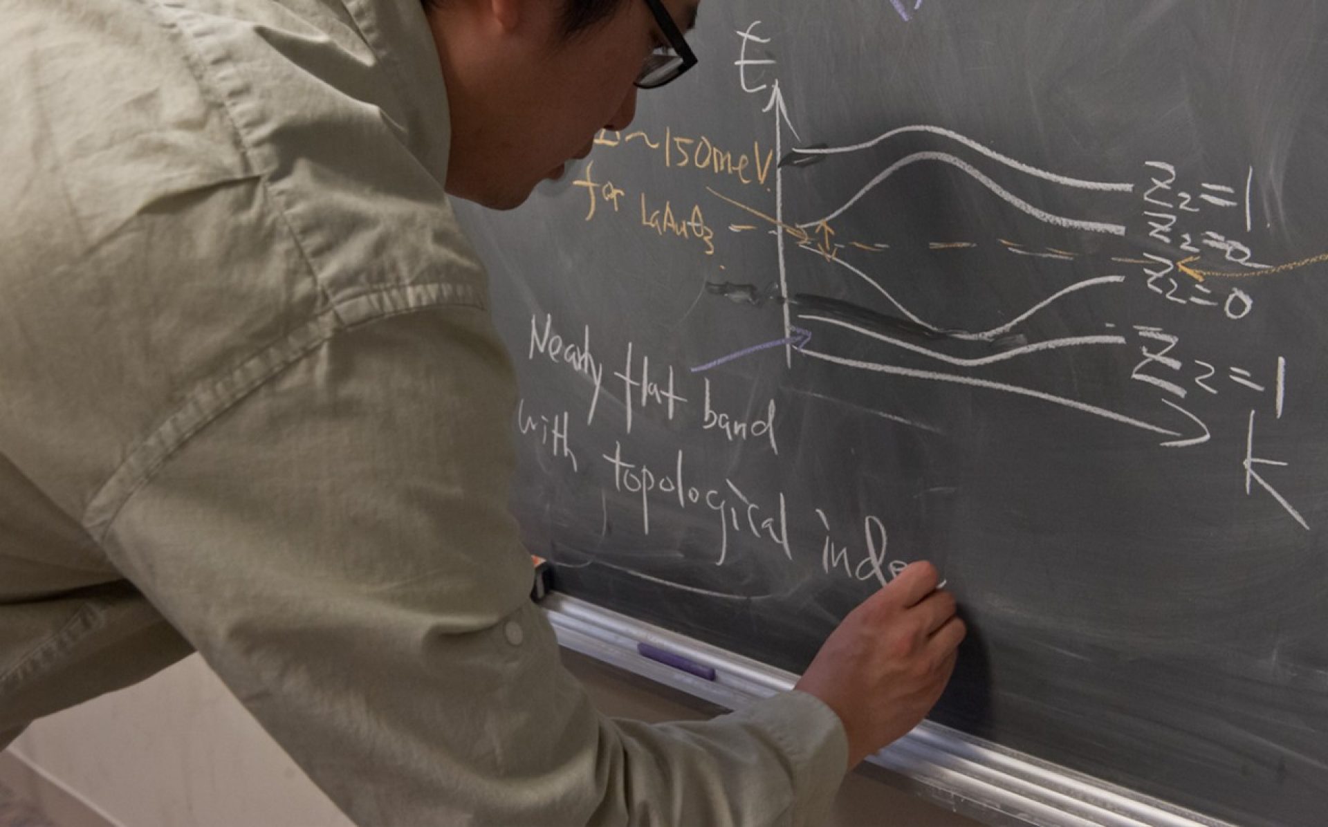 Researcher writing and equation on blackboard