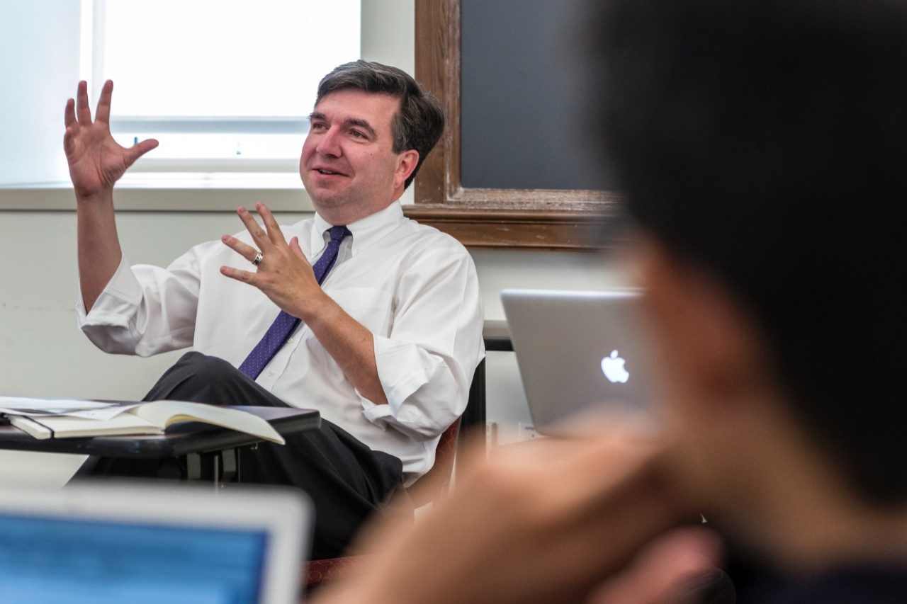 Provost David Quigley in an animated conversation in a classroom