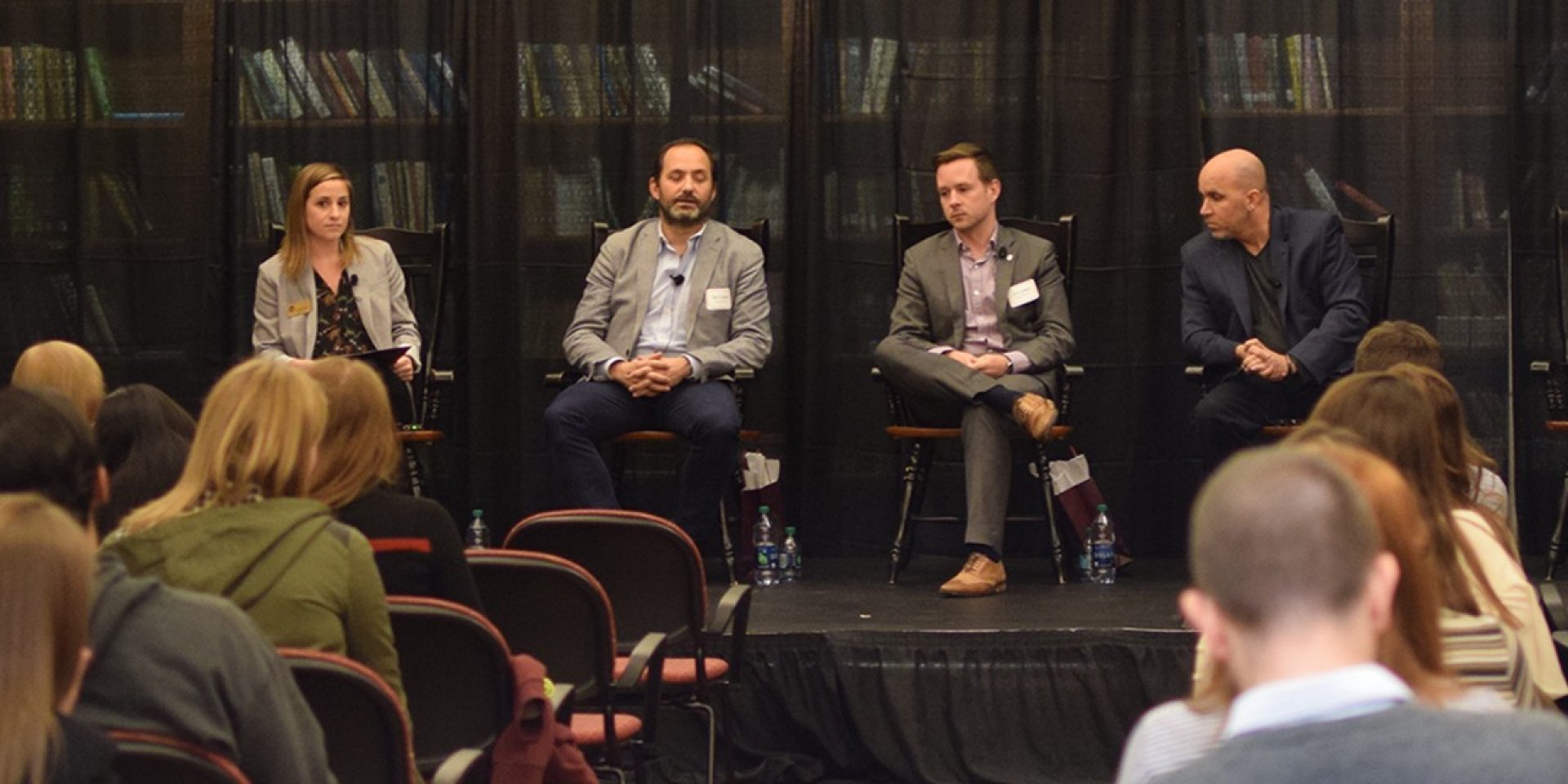 Panelists in chairs in front of an audience