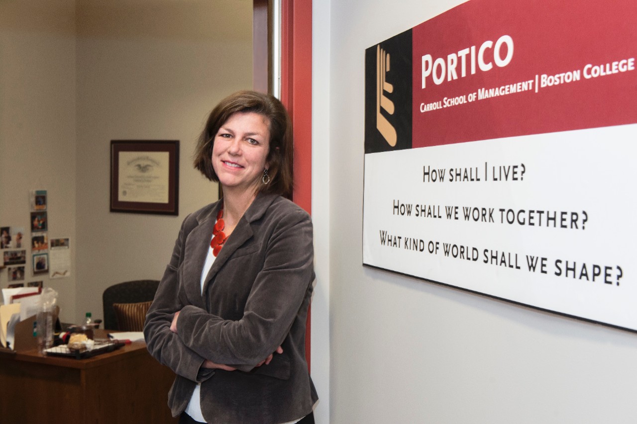 Amy LaCombe posing by a Portico sign