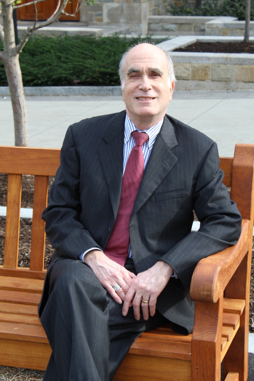 Professor Len Evenchik sitting on a bench on Boston College's Campus
