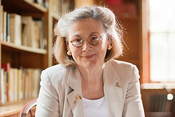 Headshot of woman professionally dressed, with shoulder-length hair and glasses