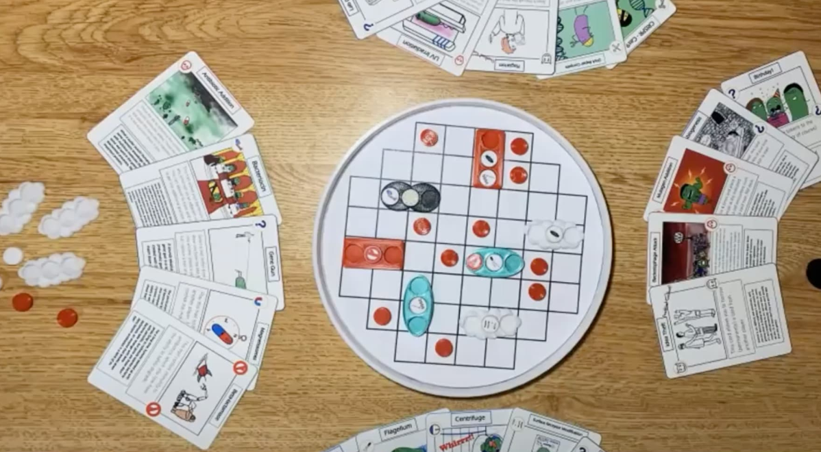 A board game set up with a round playing board and cards on a table