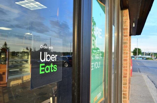 "Order with Uber Eats" sign in window of Subway restaurant 