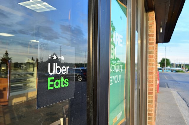 "Order with Uber Eats" sign in window of Subway restaurant