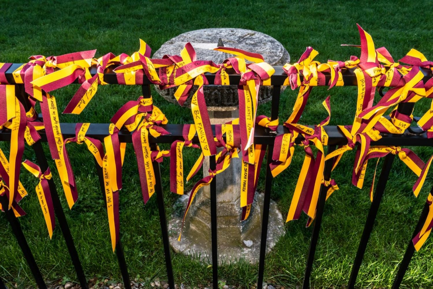 red and yellow ribbons with graduation messages written on them tied to a fence