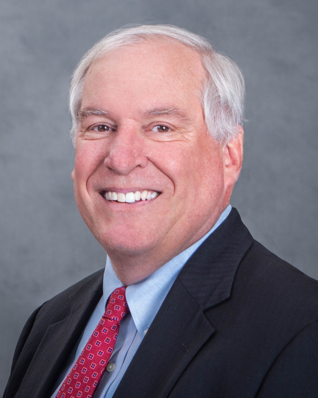 Headshot of smiling man in suit and tie