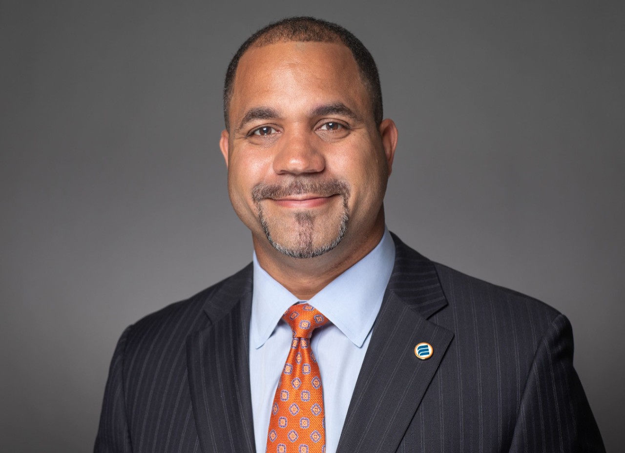 Headshot of smiling Black man in suit and tie