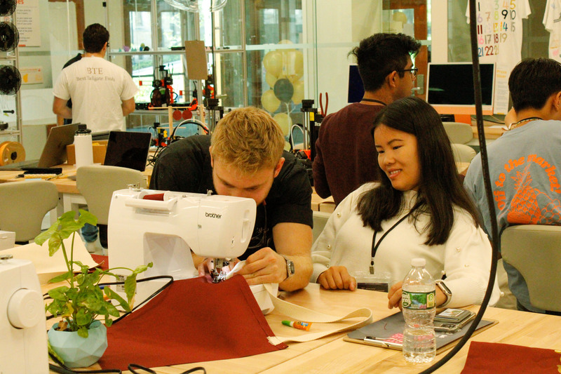 students working together over a sewing machine in The Hatchery