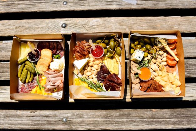 Charcuterie boxes sitting on a bench