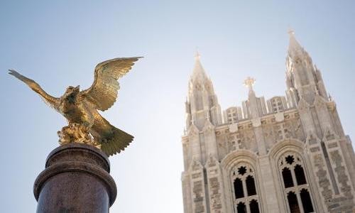 Photo of Eagle statue with Gasson Hall tower in the background