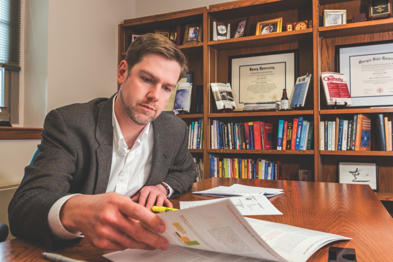 Photo of Professor Kane reading at his desk
