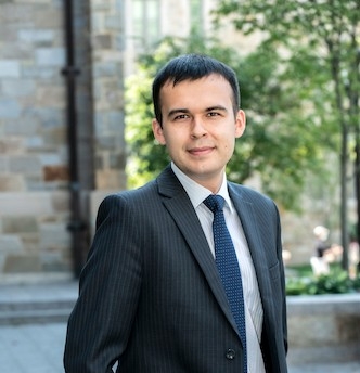 Photo of Man in suit standing outside stone building