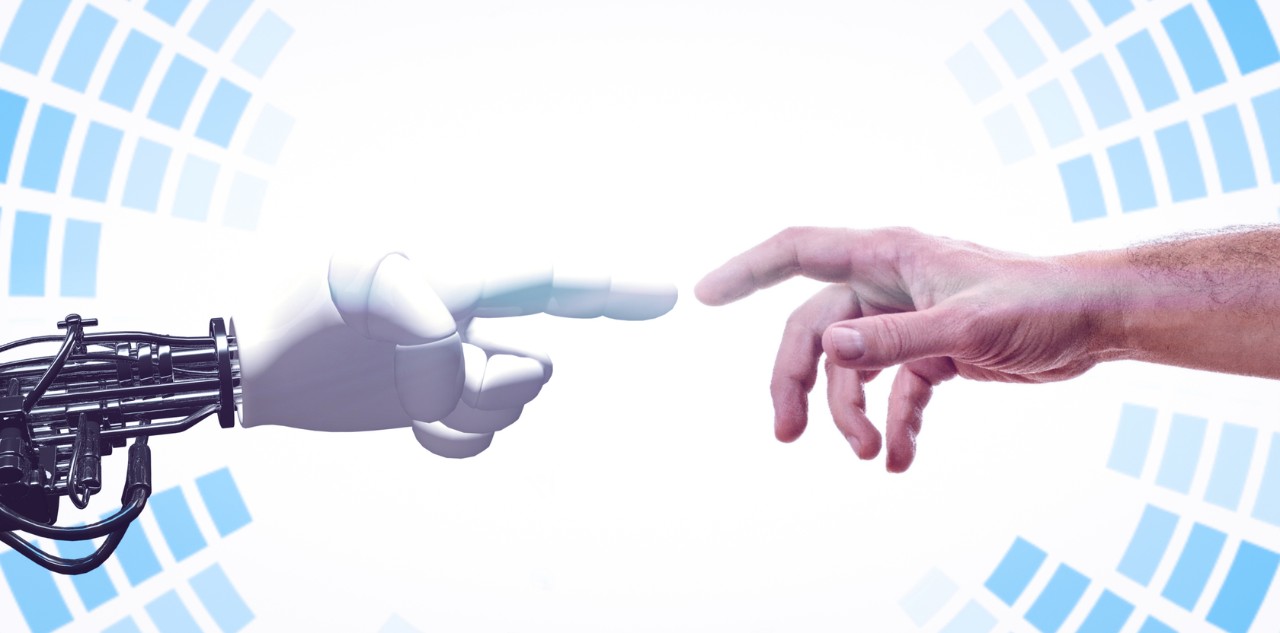 Photo of robot hand reaching for a human hand, reminiscent of Michelangelo's The Creation of Adam
