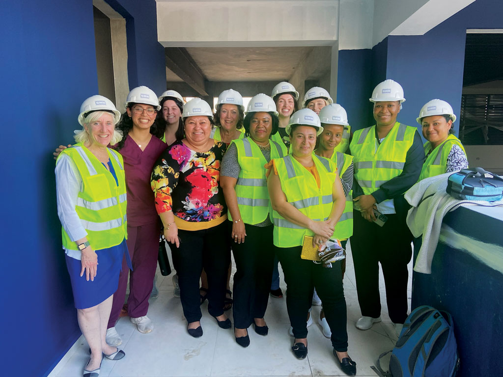 Students and faculty in hard hats and construction vests