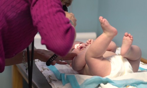 Nursing student examining baby