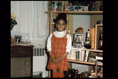 A young Black girl in a red and white dress