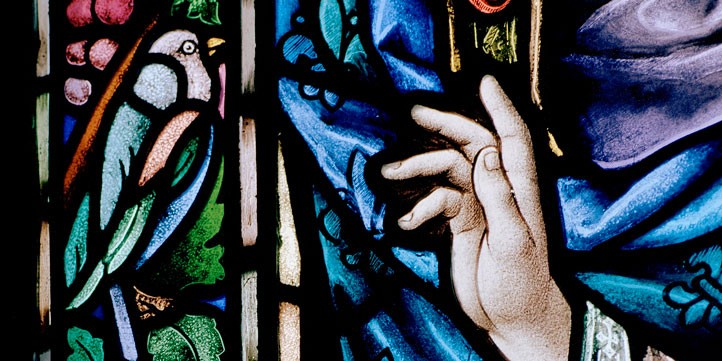 Stained glass image of bird and hand