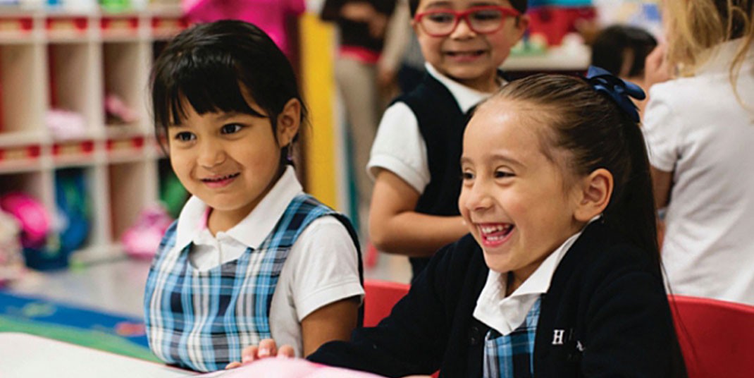Two girls in Catholic school uniforms smiling 