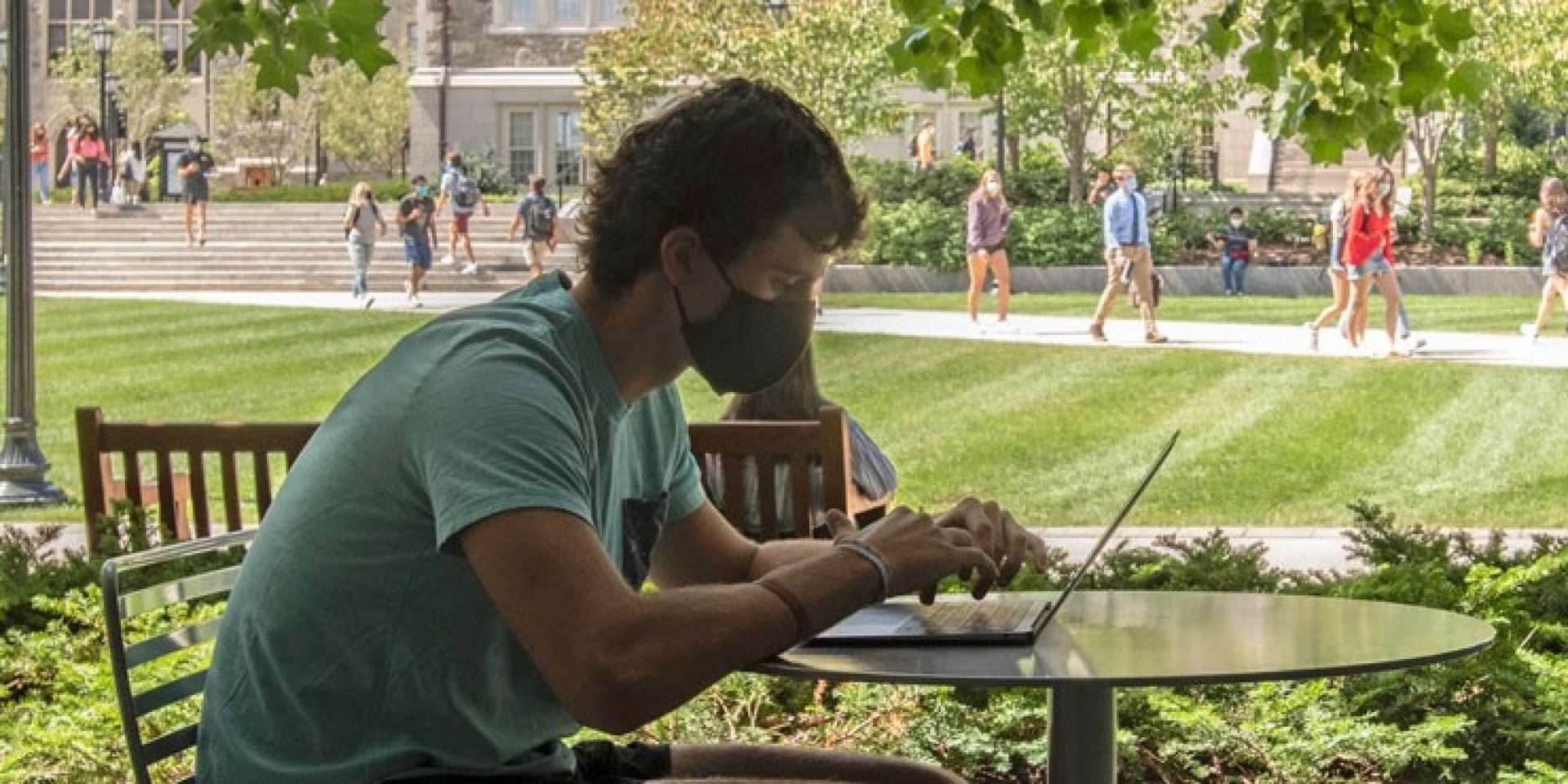 Student on computer outside O'Neill library