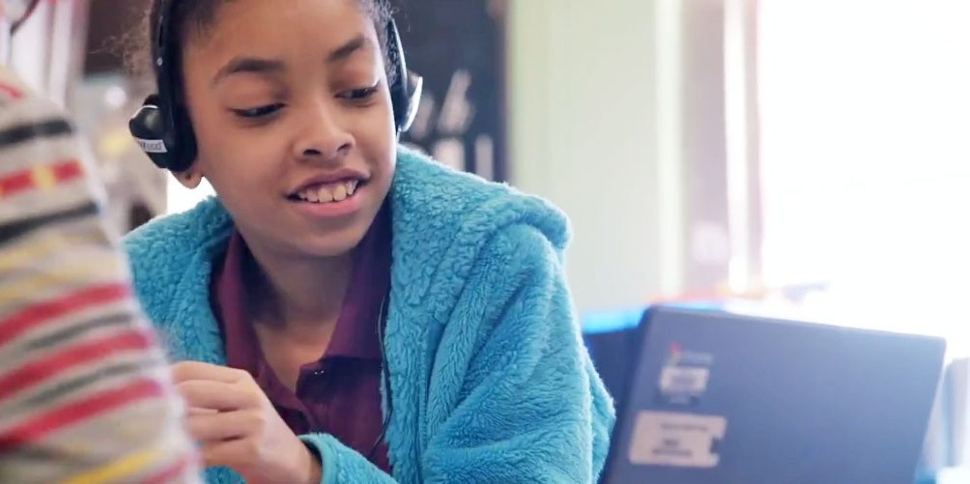 City Connects student with headphones looking at computer