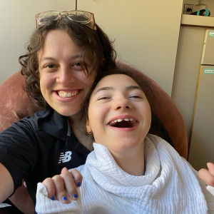 A teacher and student sitting together and laughing