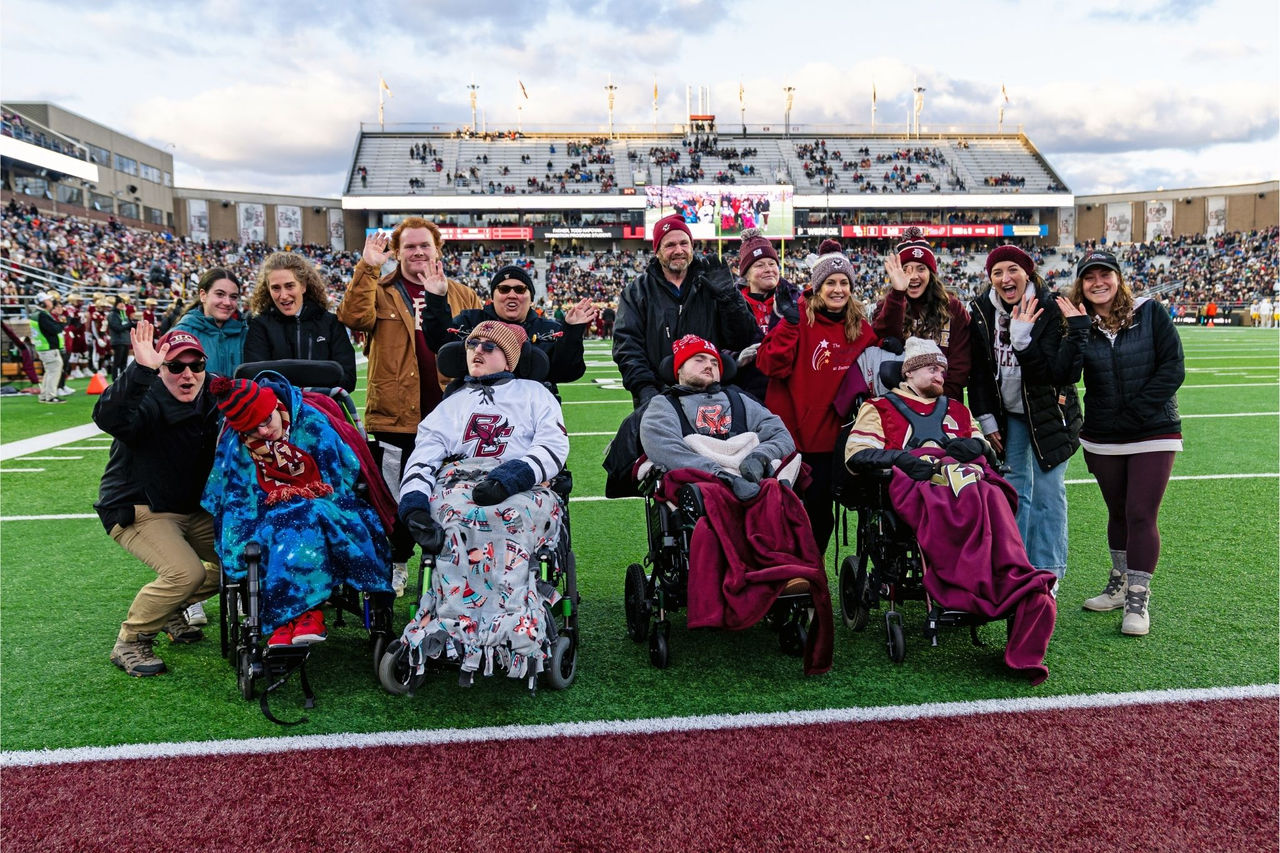 Campus School students, their parents, and volunteers on field during a football game at Alumni Stadium