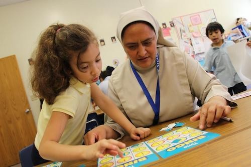 Teacher speaking with student while looking at activity sheet