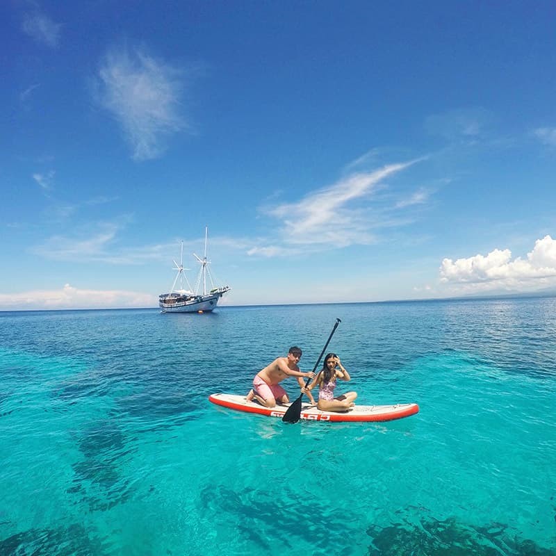 Liana Lopez '20 paddleboards over clear waters in Apo Island, Dumaguete, one of seven thousand islands in the Philippines