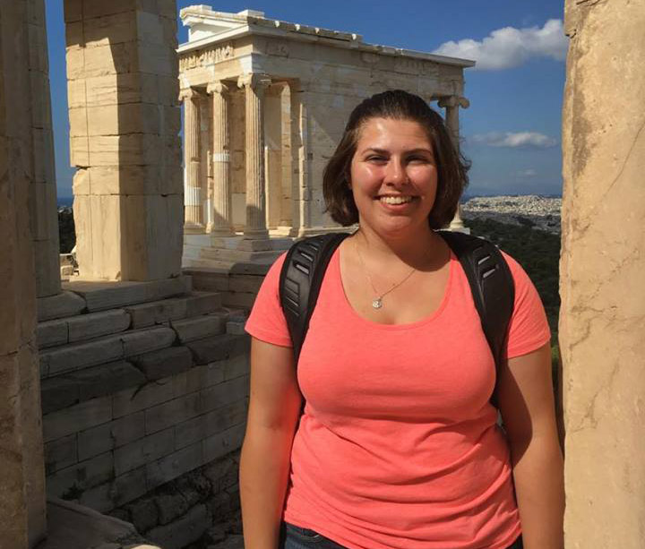 A woman standing in front of the Acropolis