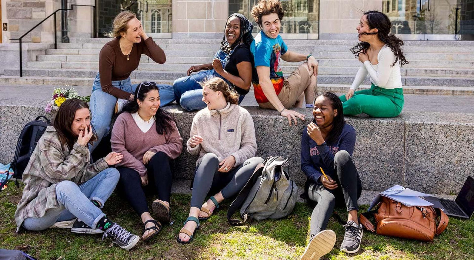 A group of eight BC students talking and laughing.