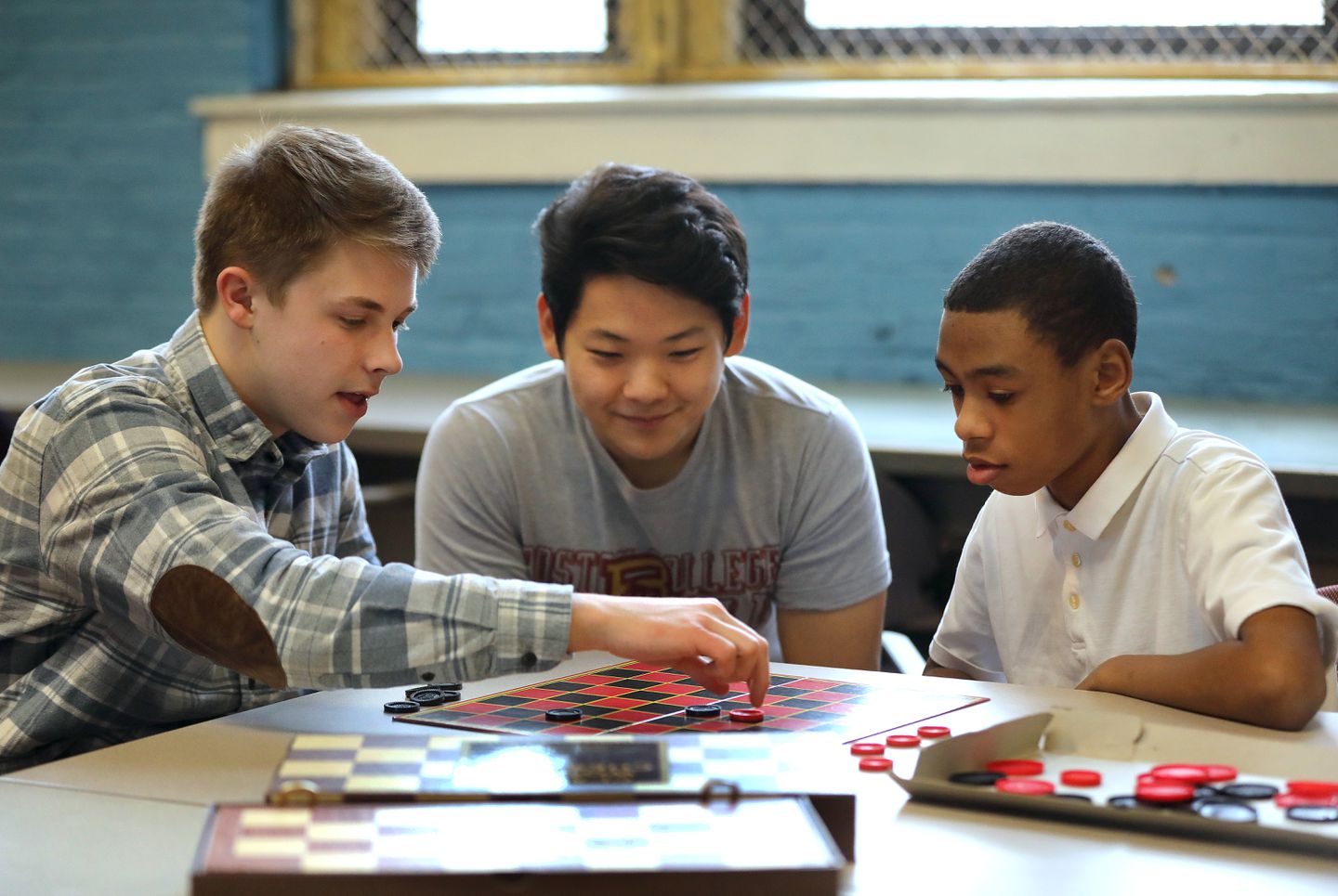 Photo of student volunteering and playing checkers