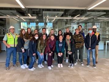 Photo of Image of Environmental Studies students posing with construction workers