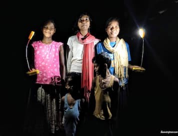 Photo of Image of several people holding lights in a dark space