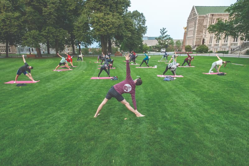 Students engage in a yoga practice on the Bapst lawn