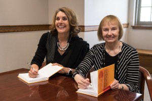 Dearing (left) and Cronin signed copies of their book during a recent symposium at Boston College entitled Leading for Social Impact.