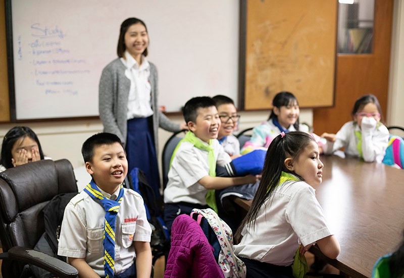 young students sitting around a classroom table