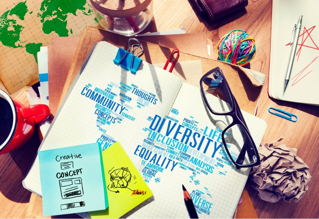 A photo of a desk with a notebook that says "diversity" and "equality"