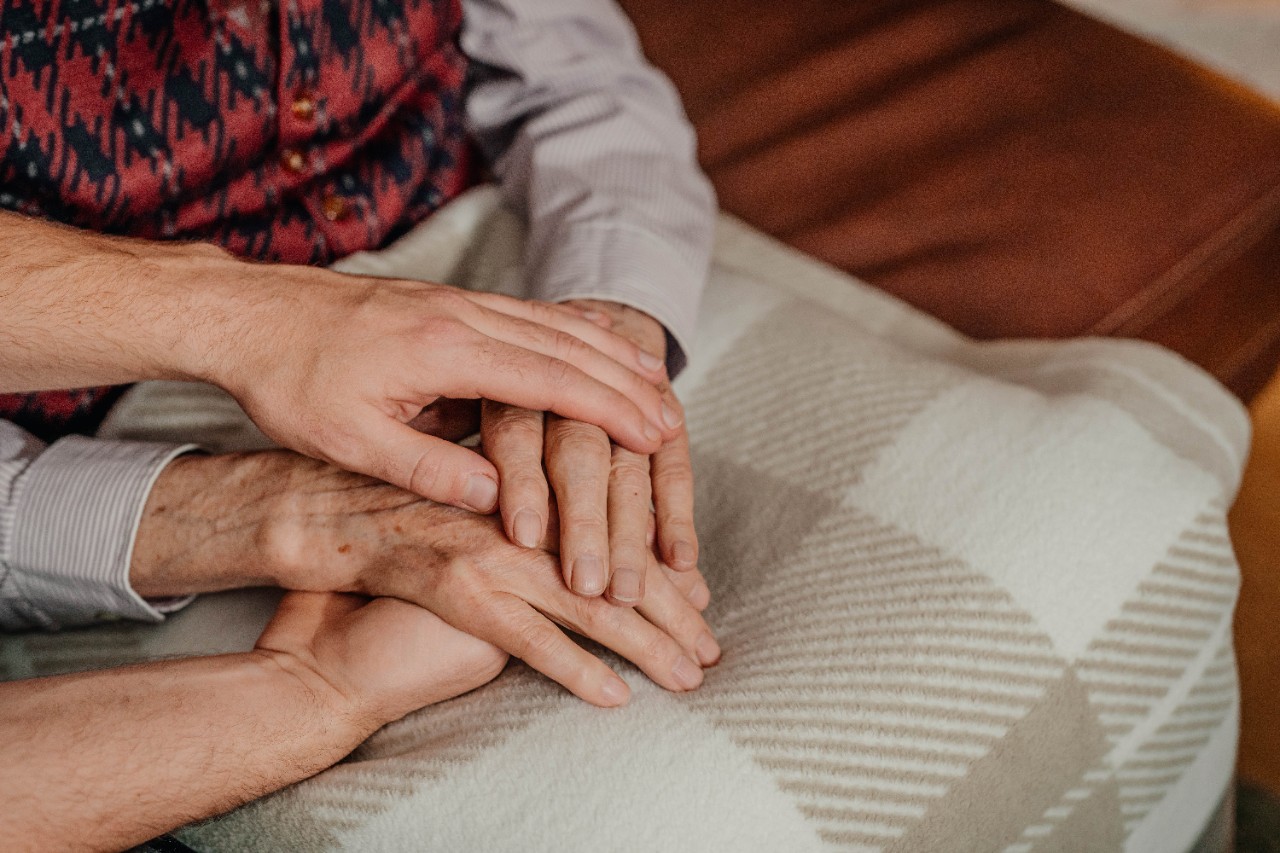 A caregiver comforts and older man