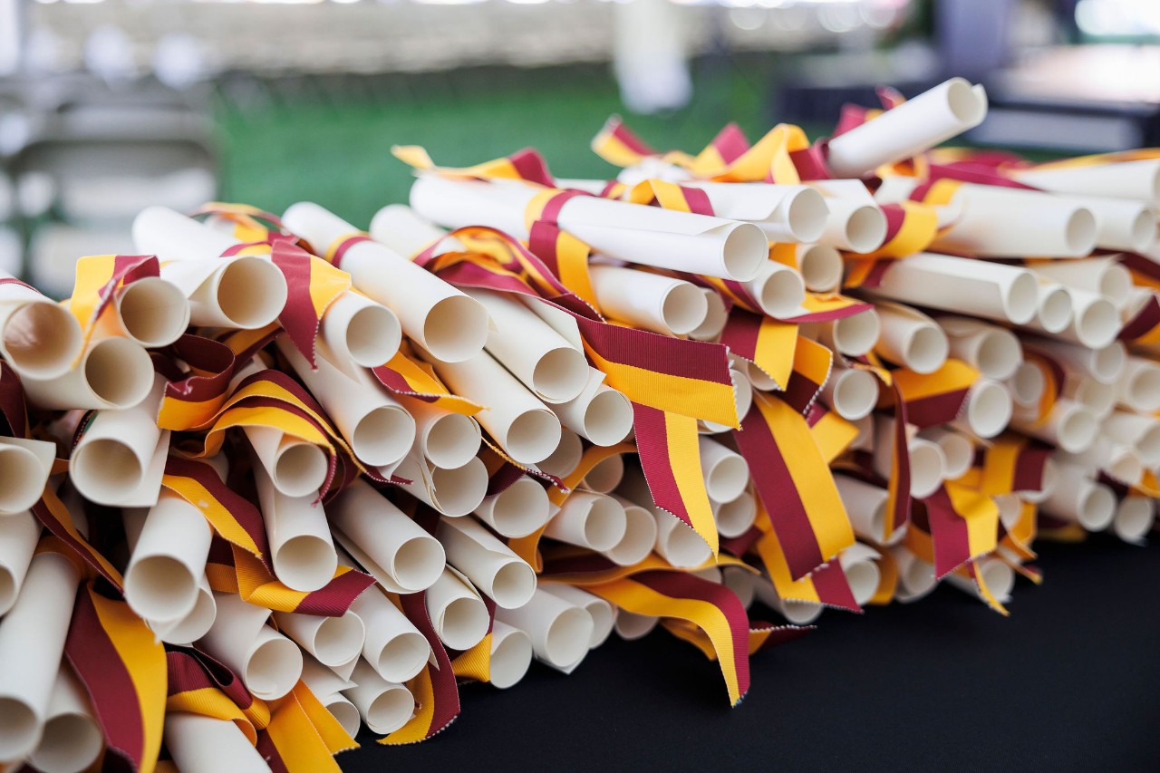 Diplomas wrapped in gold and maroon bows.