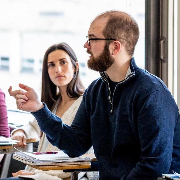 A student smiling with colleagues