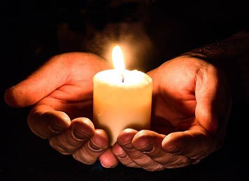 Photo of hands holding candle